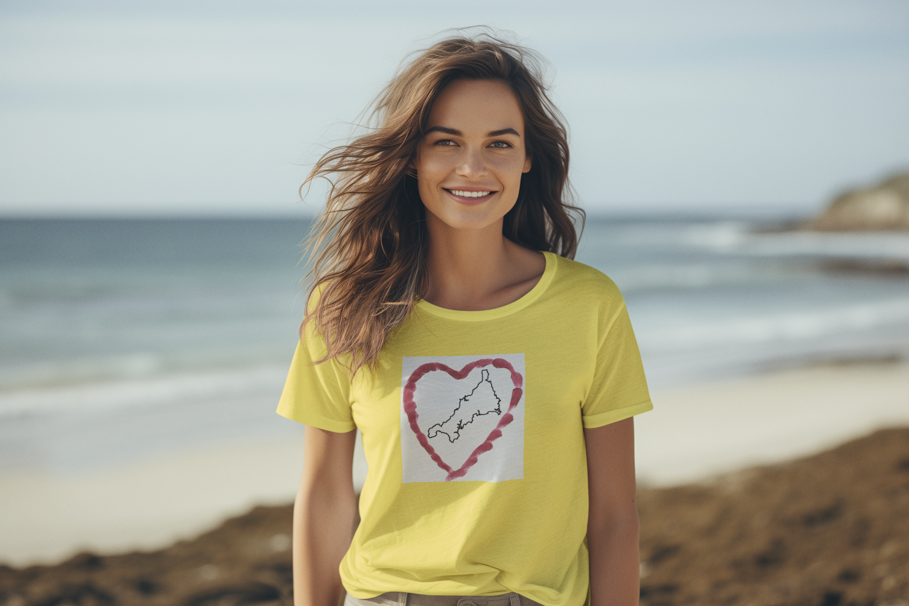 Girl in Yellow Cornwall graphic t-shirt with Kernow heart map — coastal lifestyle tee