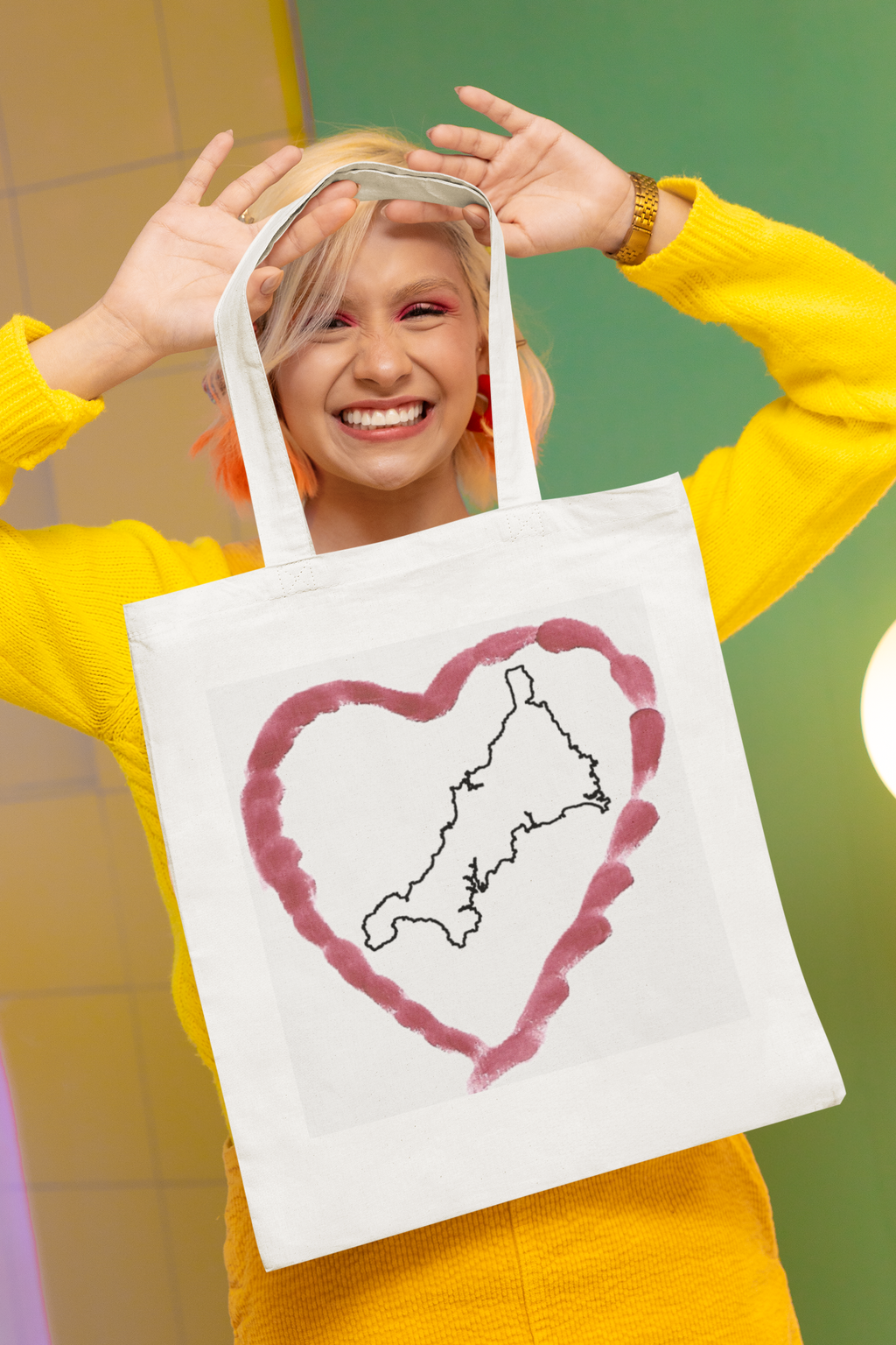 Happy woman holding I Love Cornwall tote bag — Kernow heart map cotton gift shopper