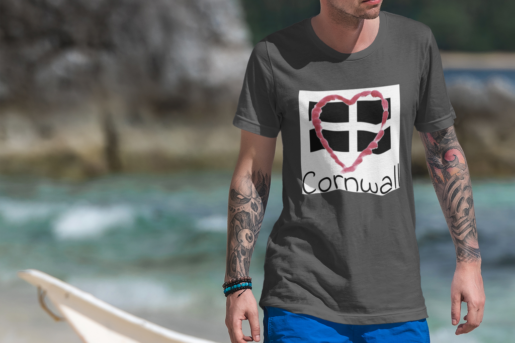 Man wearing Asphalt Cornwall Heart Flag t-shirt on rocky Cornwall beach
