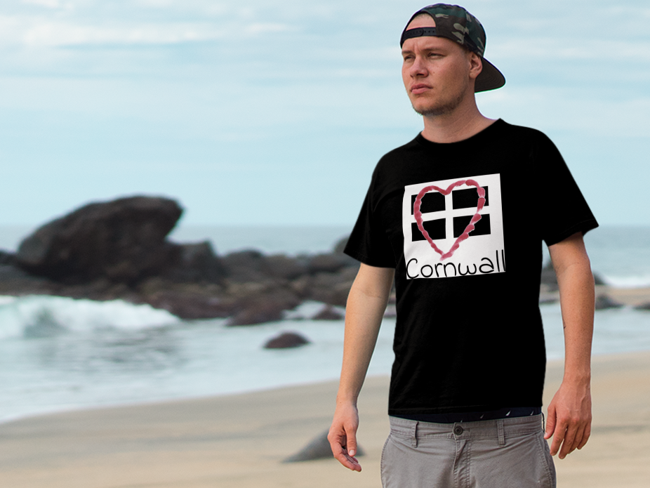 Man wearing black Cornwall Heart Flag t-shirt on beach, St Piran flag graphic tee