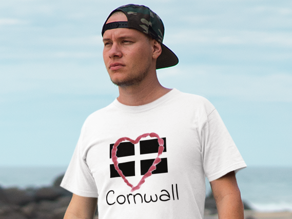 Man wearing white Cornwall Heart Flag t-shirt on beach, St Piran flag graphic tee