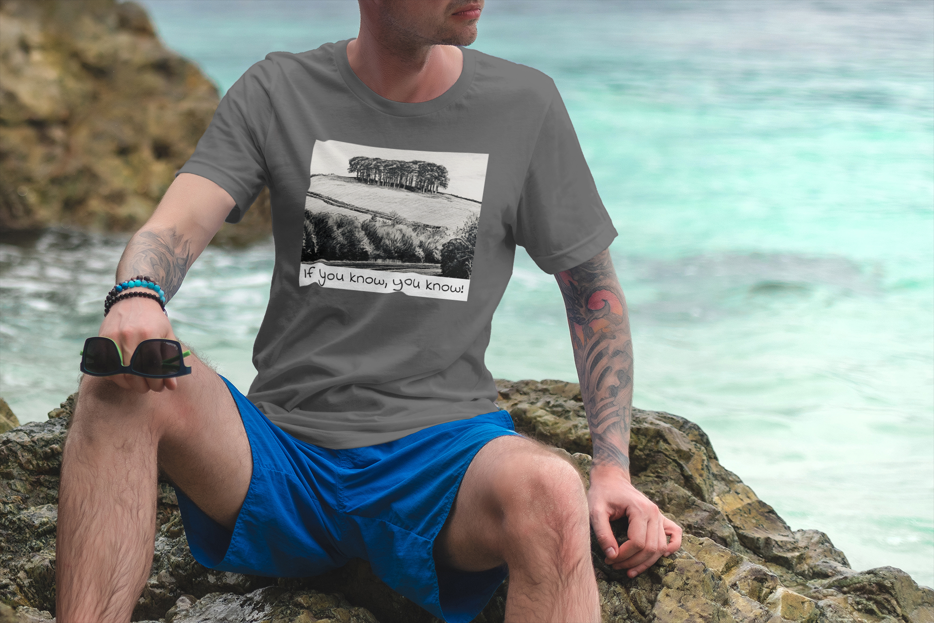 Model wearing Asphalt Nearly There Trees Cornwall t-shirt on the beach, holiday tee