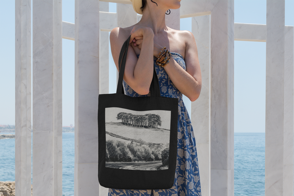 Woman carrying black Nearly There Trees Cornwall tote bag on coastal walkway