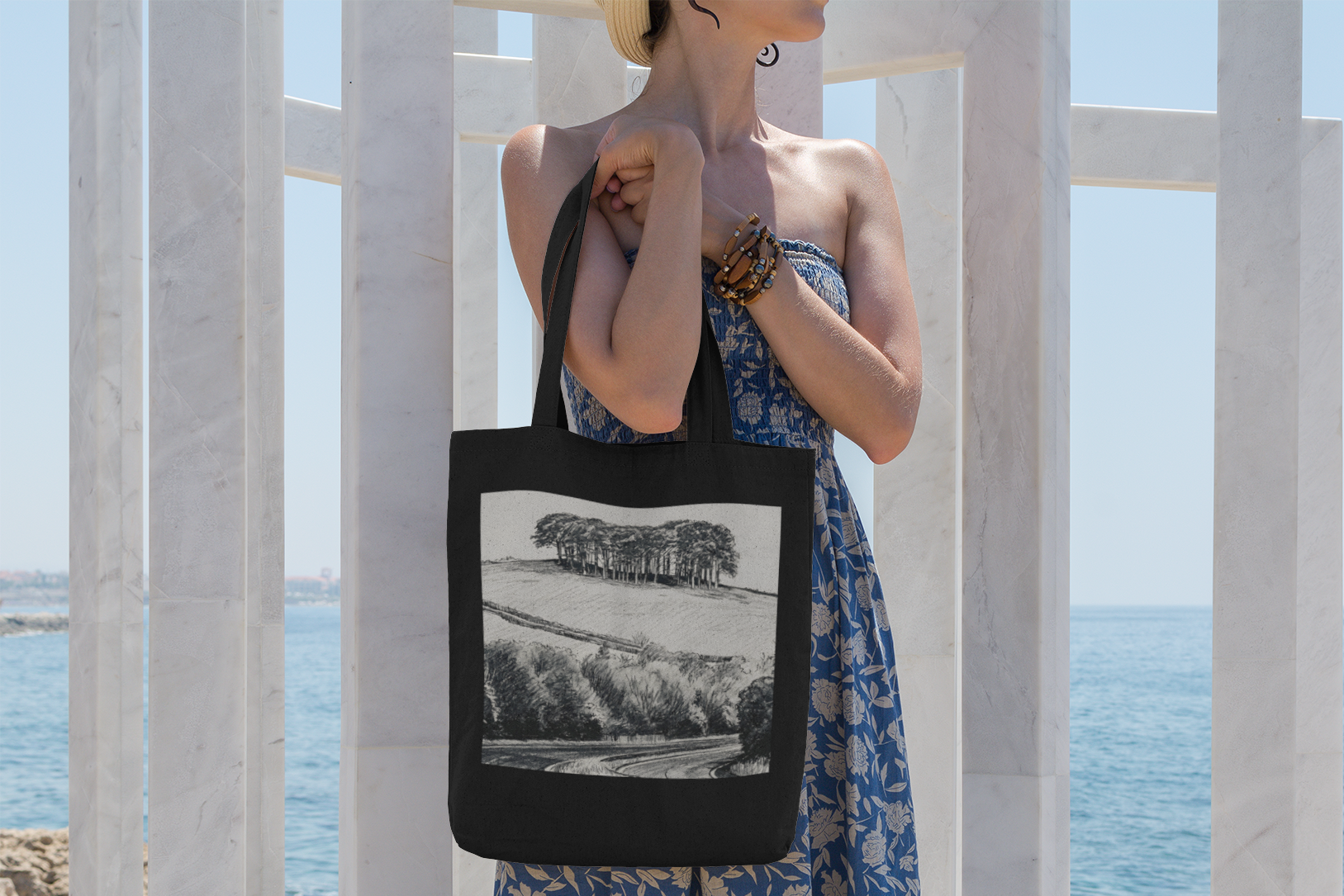 Woman carrying black Nearly There Trees Cornwall tote bag on coastal walkway