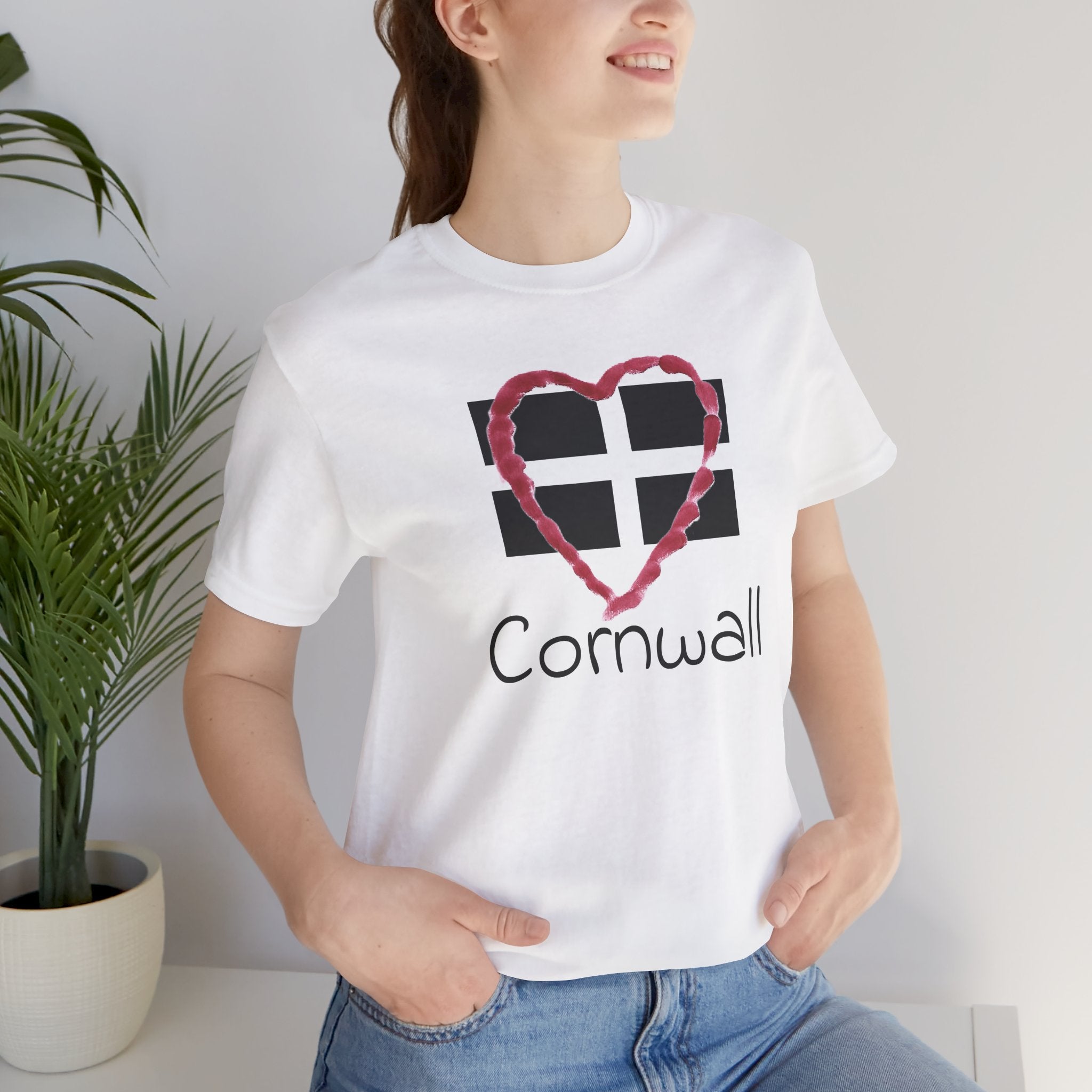 Woman sitting in holiday homewearing White Cornwall Heart Flag graphic tee, casual outfit