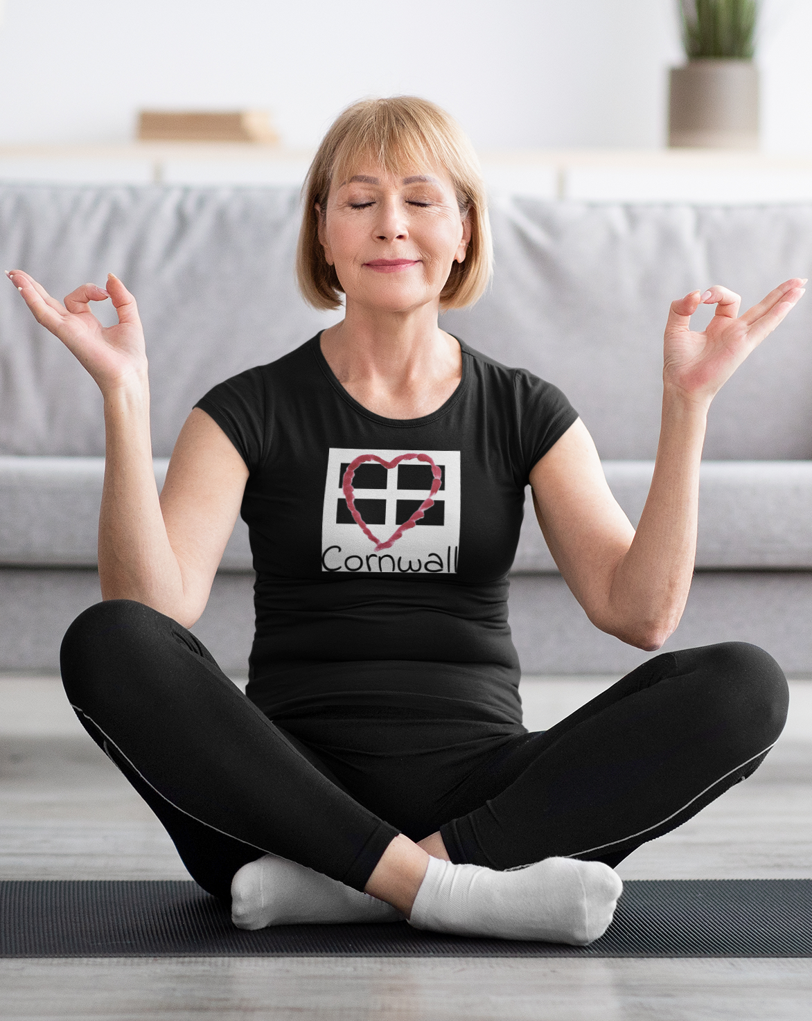 Woman sitting wearing Black Cornwall Heart Flag graphic tee, casual outfit