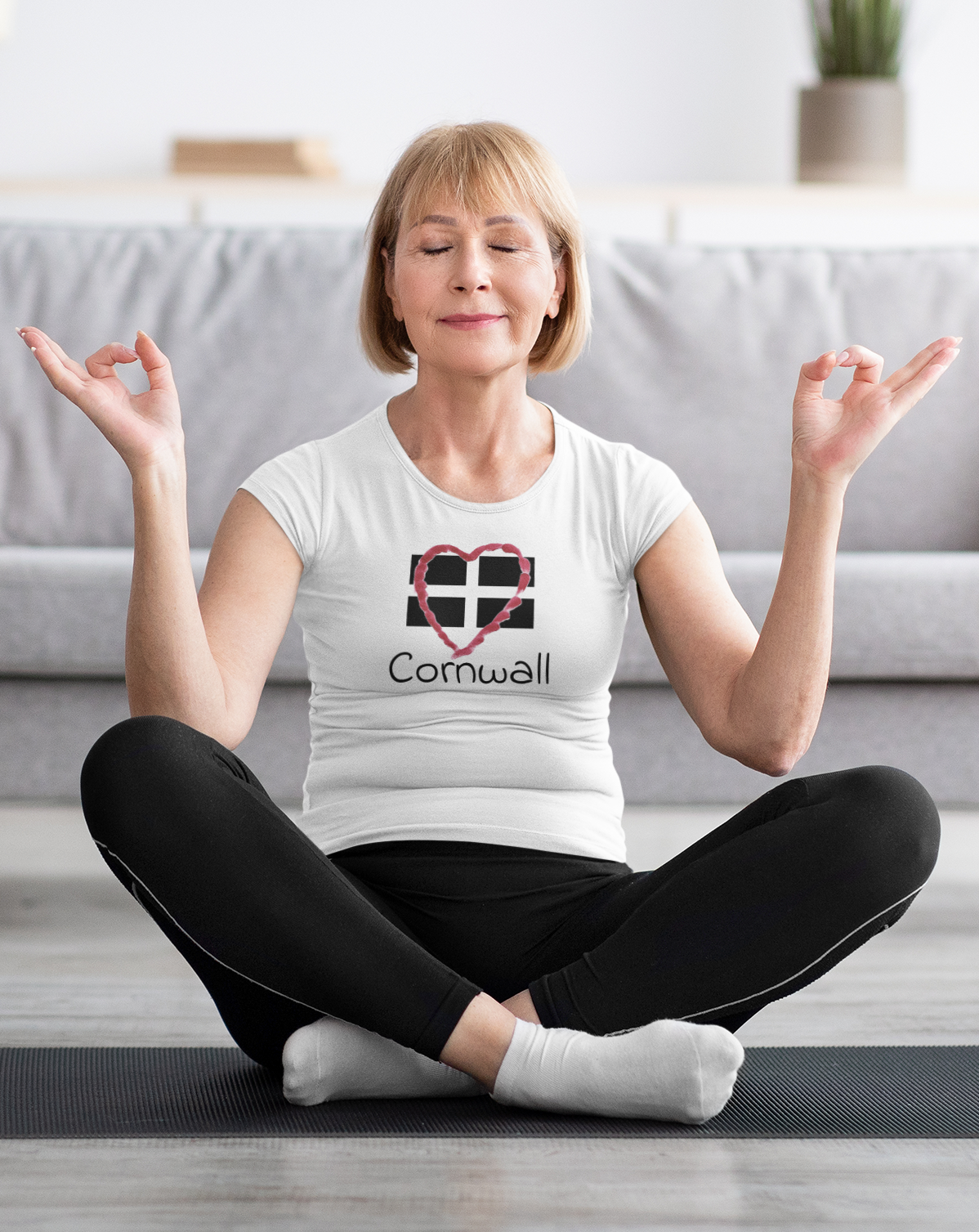 Woman sitting wearing White Cornwall Heart Flag graphic tee, casual outfit