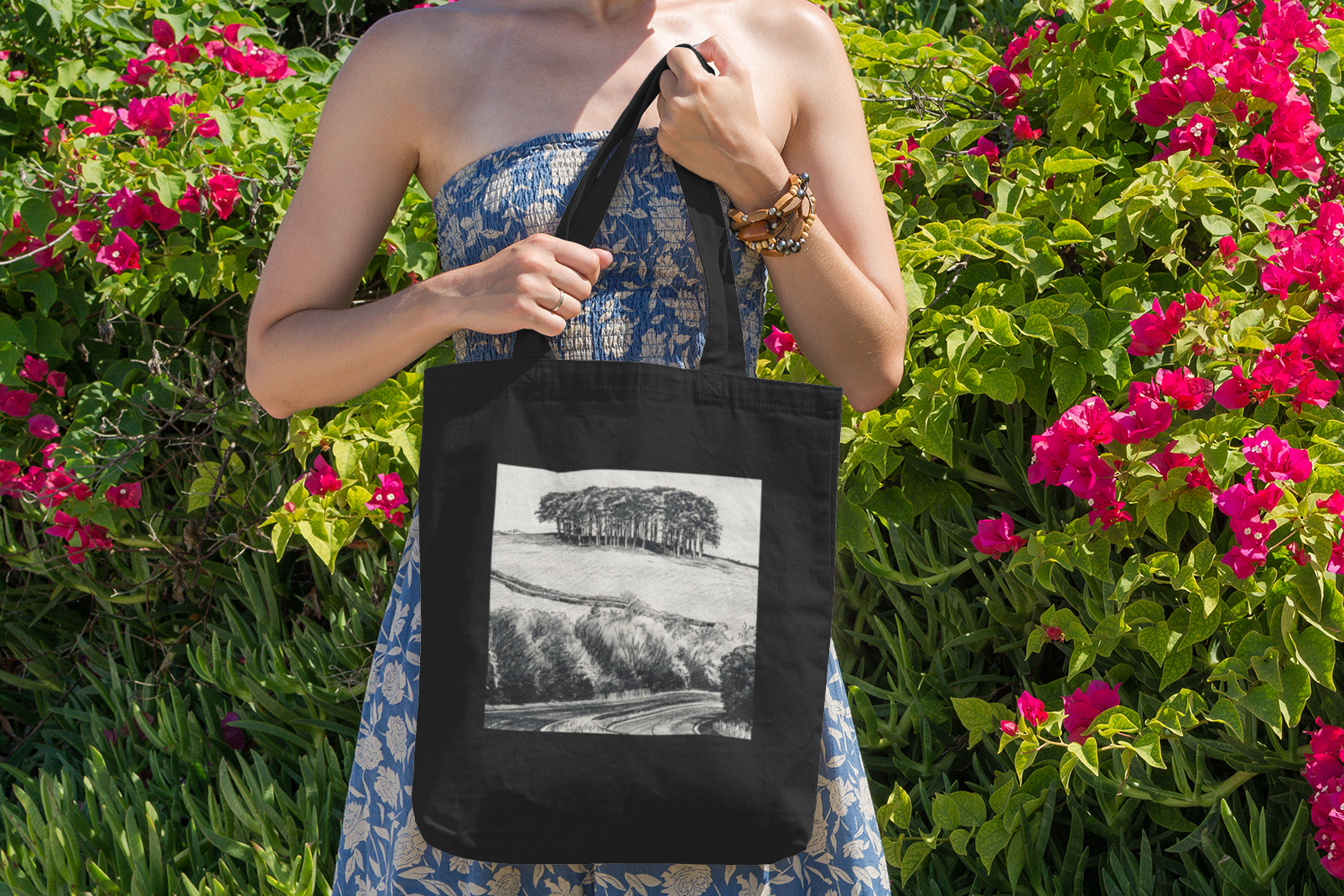 Woman with black Nearly There Trees Cornwall tote bag near flowers, holiday gift bag