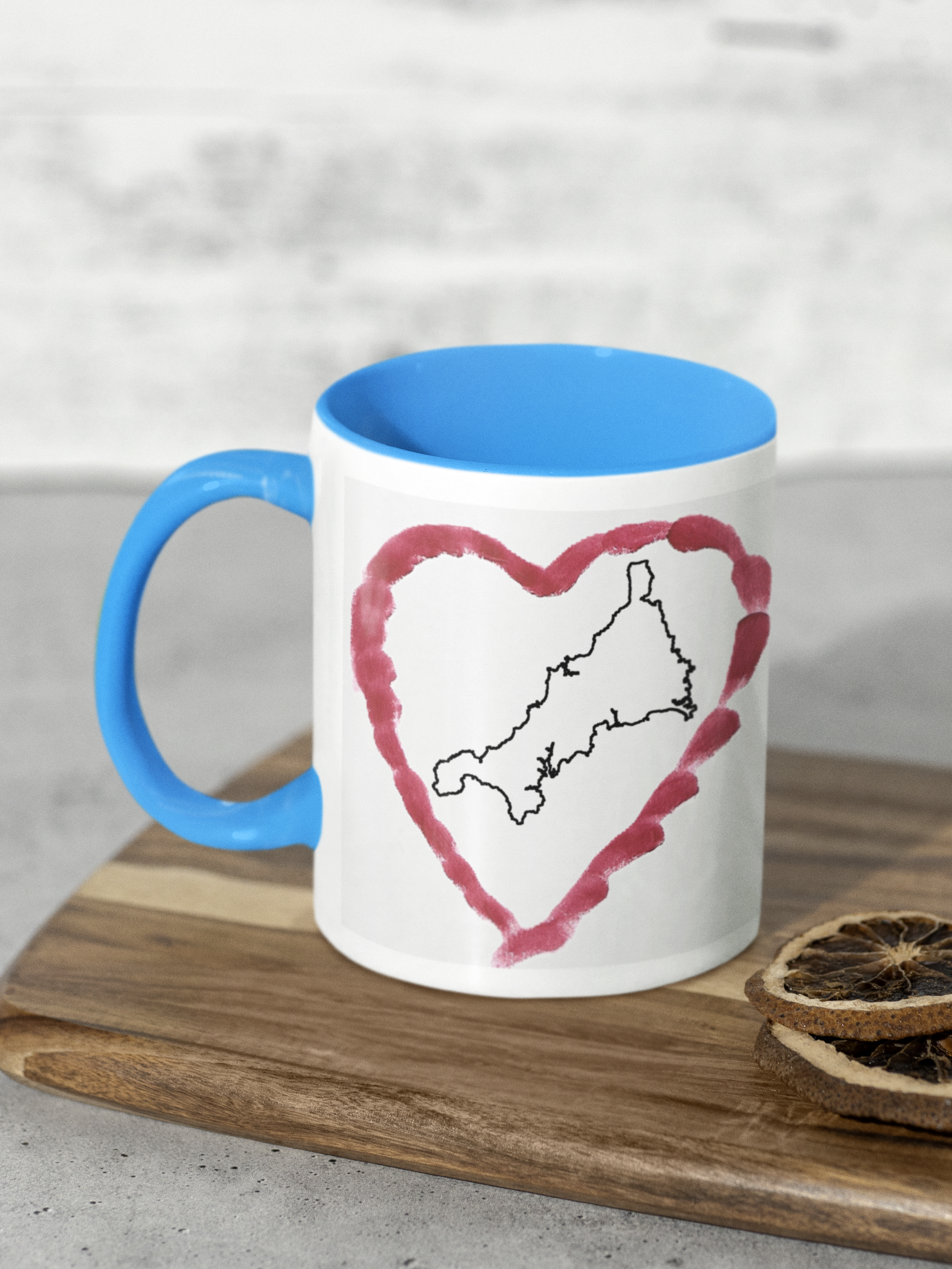 I Love Cornwall heart map mug with light blue handle on wooden board, Cornwall outline design