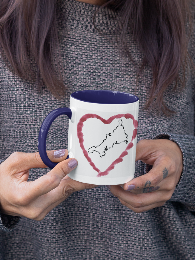 Hands holding I Love Cornwall heart map mug with navy handle, Cornwall outline design