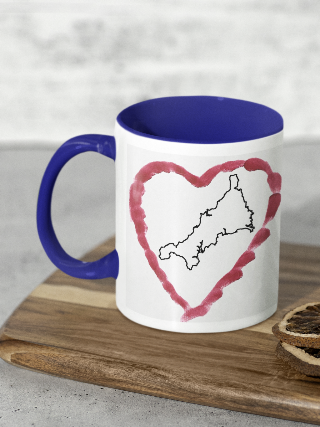 I Love Cornwall heart map mug with navy handle on wooden board, Cornwall outline design
