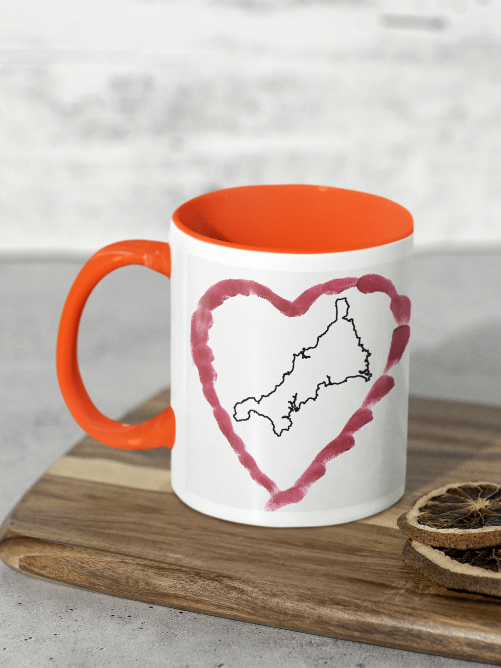 I Love Cornwall heart map mug with orange handle on wooden board, Cornwall outline design