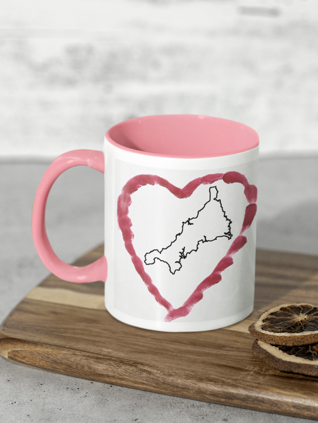 I Love Cornwall heart map mug with pink handle on wooden board, Cornwall outline design