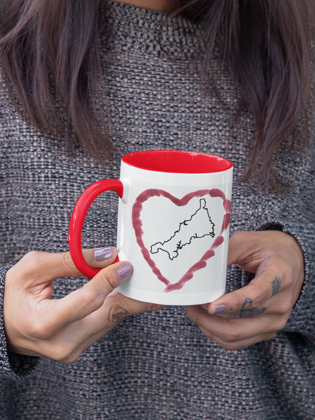 Hands holding I Love Cornwall heart map mug with red handle, Cornwall outline design