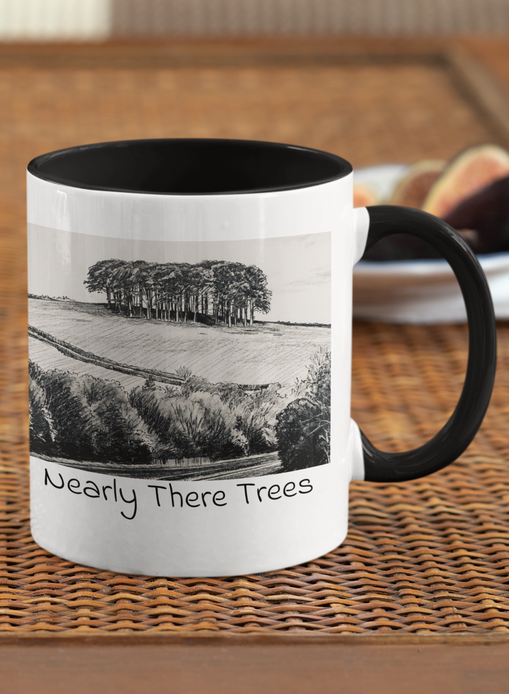 Nearly There Trees Cornwall mug with black handle on wicker table, pencil sketch tree design