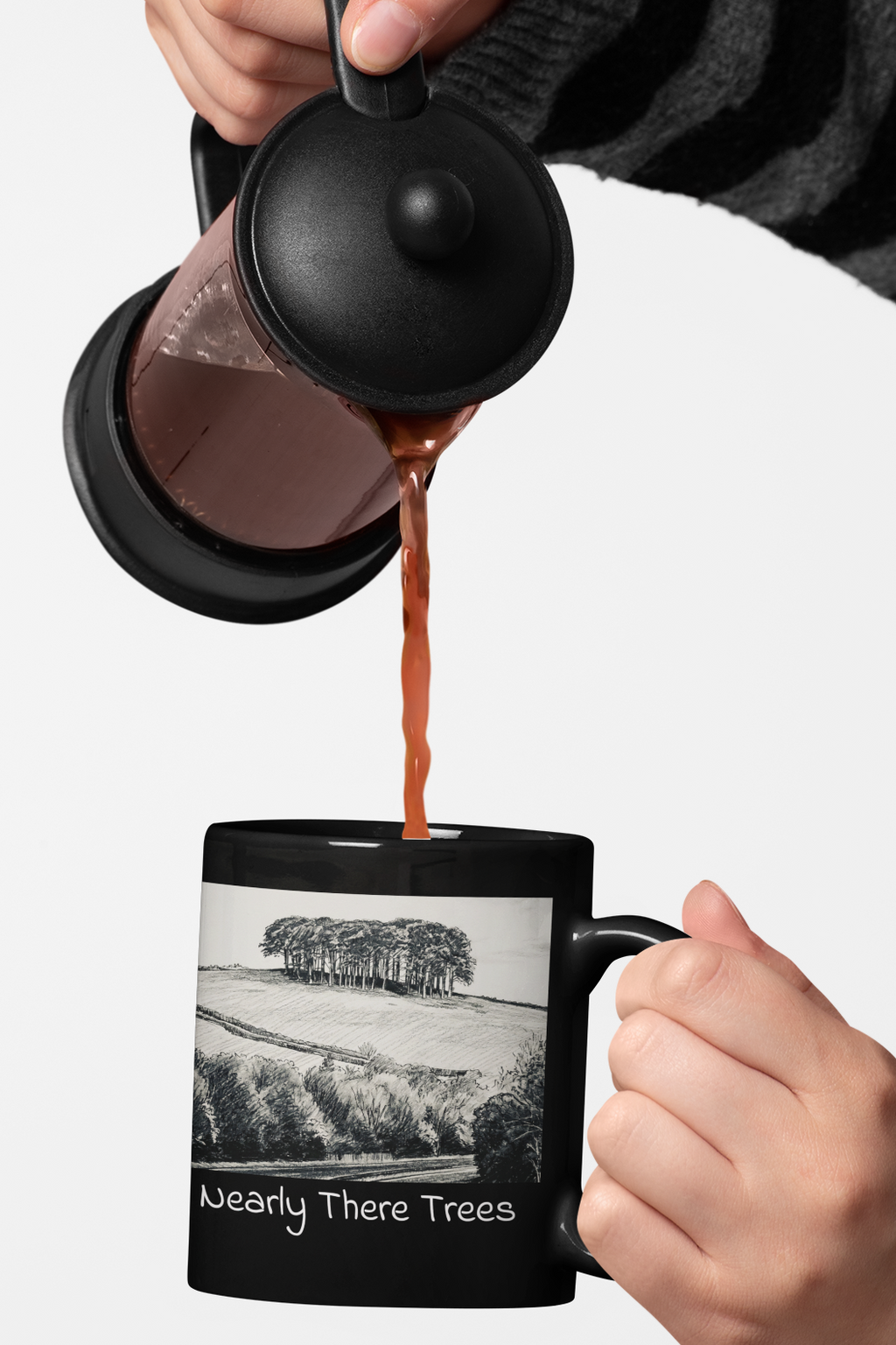 Coffee being poured into Nearly There Trees all-black mug, Cornwall tree landscape sketch design