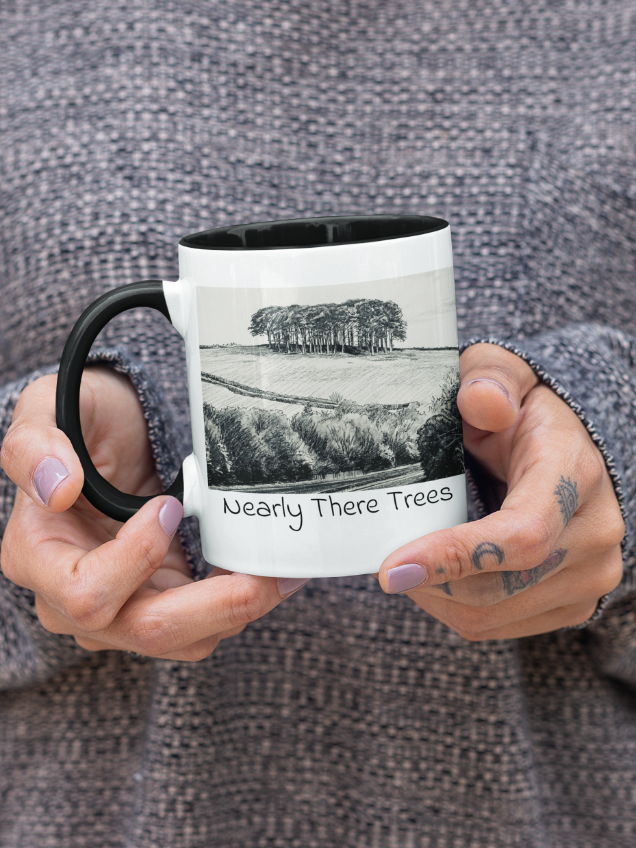Hands holding Nearly There Trees black mug, A30 Cornwall tree landscape pencil sketch design