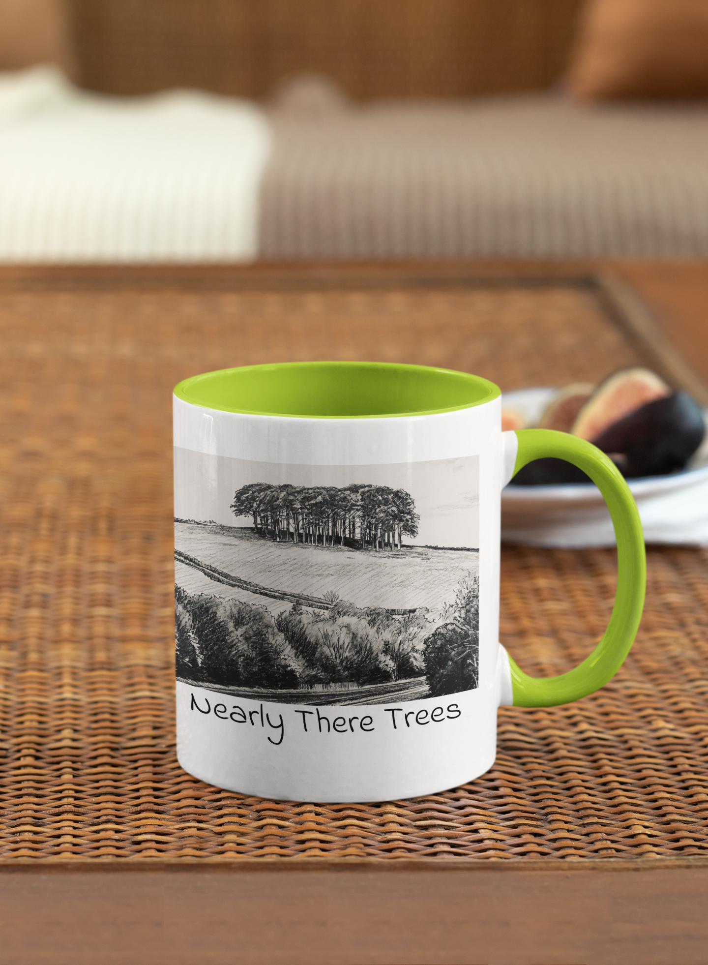 Nearly There Trees mug with green handle on wicker table, Cornwall tree landscape pencil sketch design