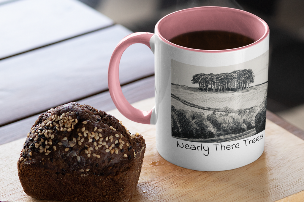 Nearly There Trees mug with pink handle and steaming coffee beside muffin, Cornwall tree sketch design