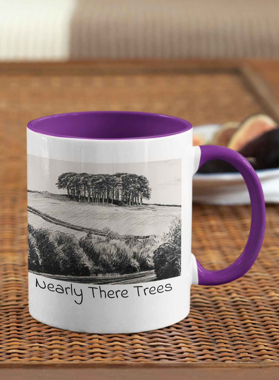 Nearly There Trees mug with purple handle on wicker table, Cornwall tree landscape pencil sketch design