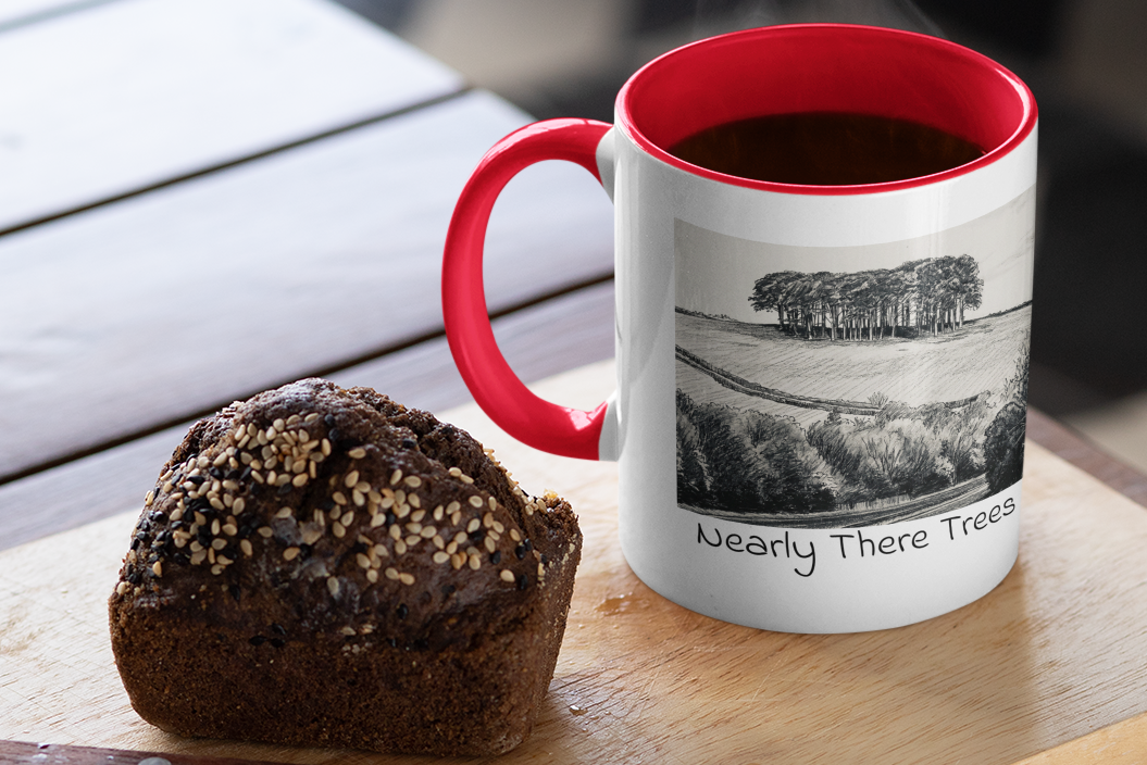 Nearly There Trees mug with red handle and steaming coffee beside muffin, Cornwall tree sketch design