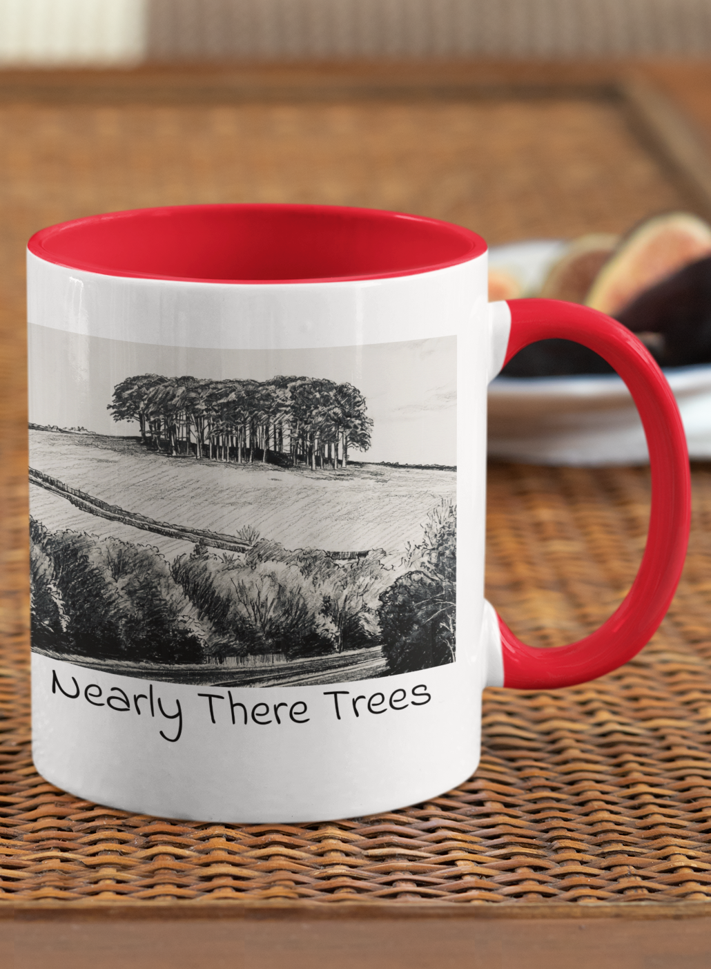 Nearly There Trees mug with red handle on wicker table, Cornwall tree landscape pencil sketch design